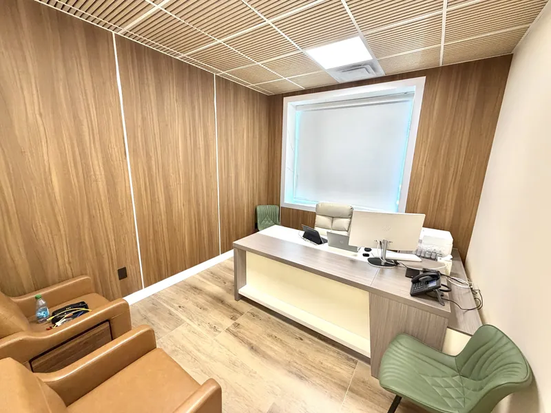 Consultation office with full-height wood-look wall panelling, a wood-slat ceiling and a custom two-tone desk